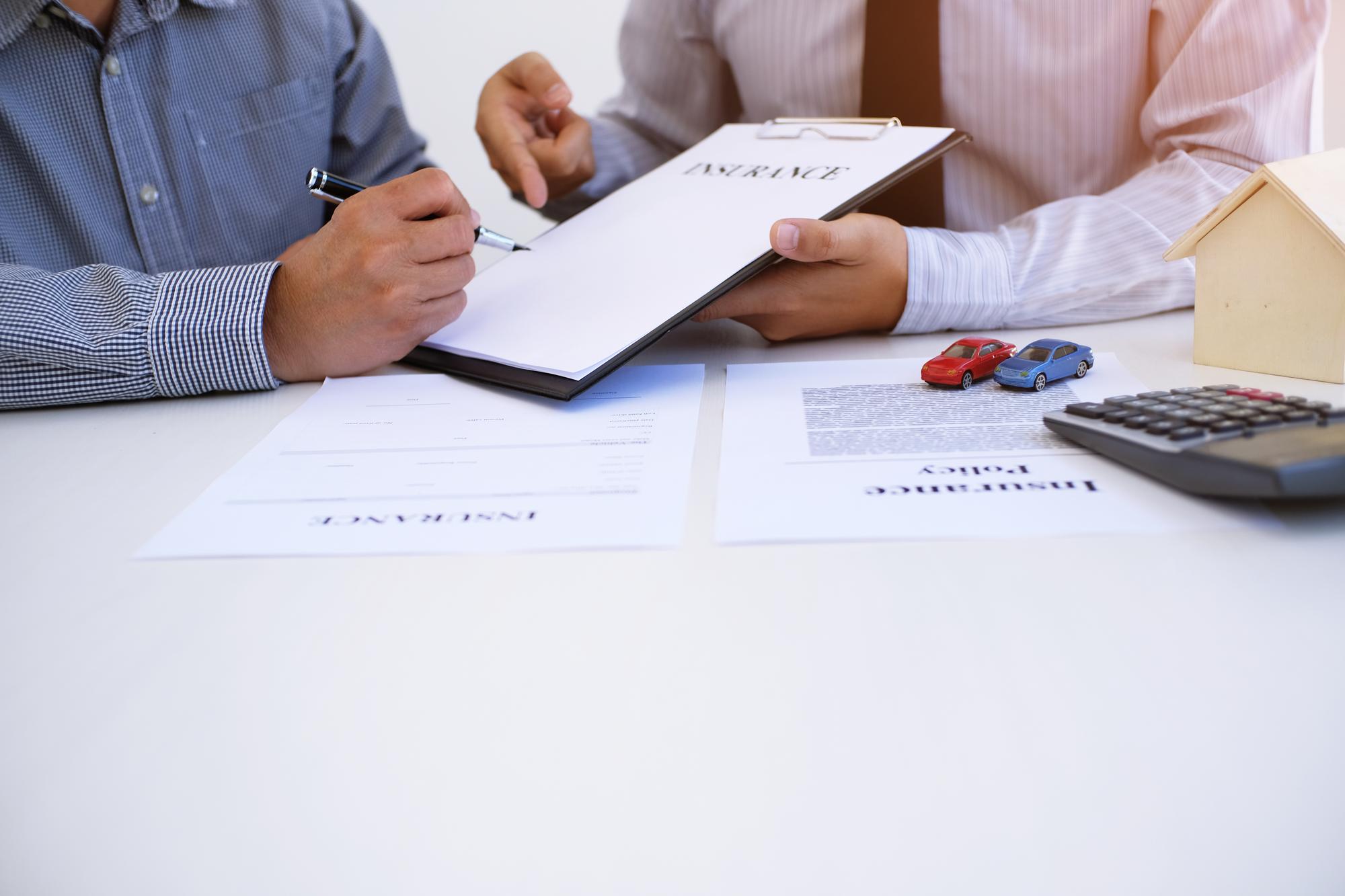 Client completing an insurance claim form with an adjuster