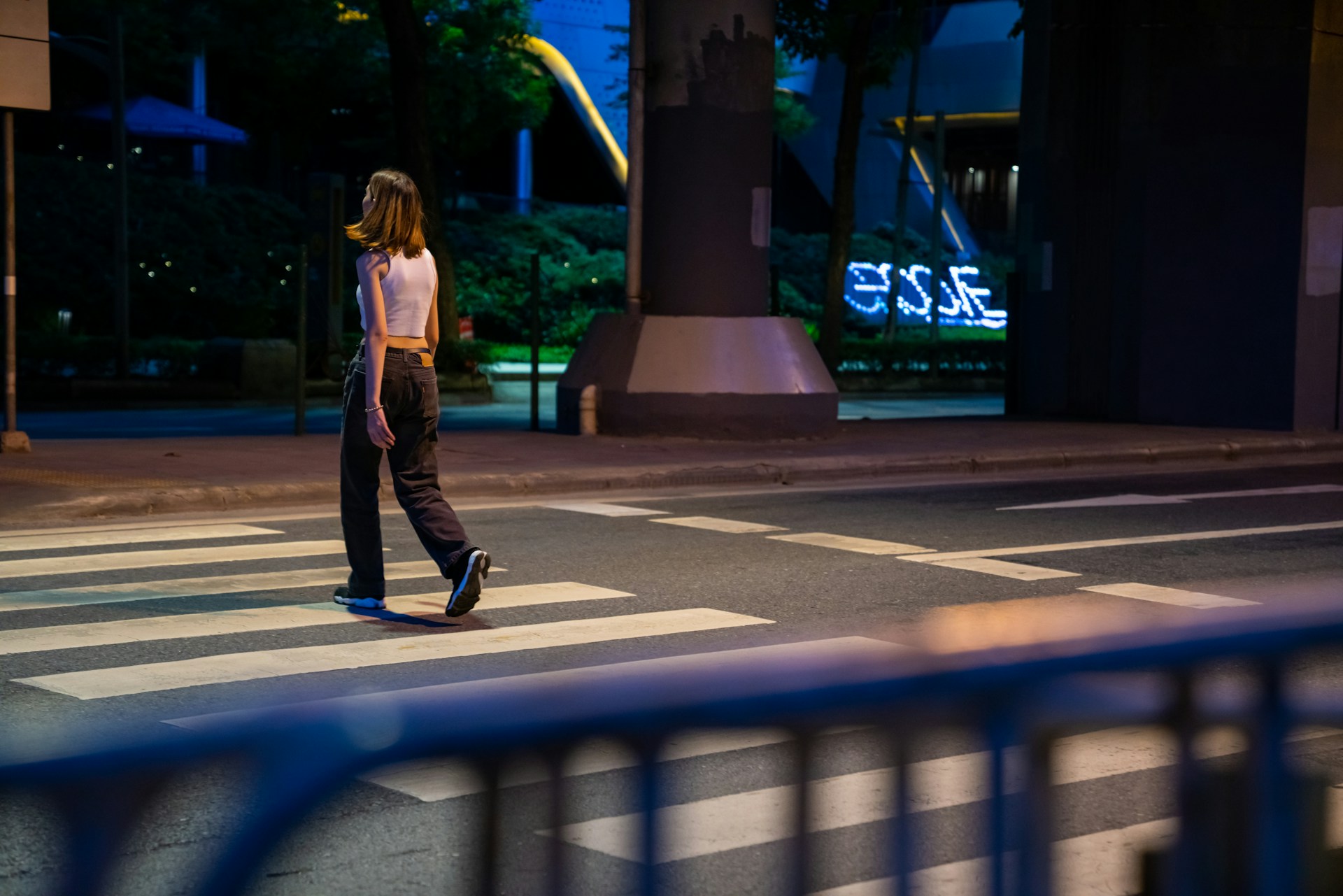 Pedestrian crossing a dark street at night, illustrating night time pedestrian dangers in Roseville
