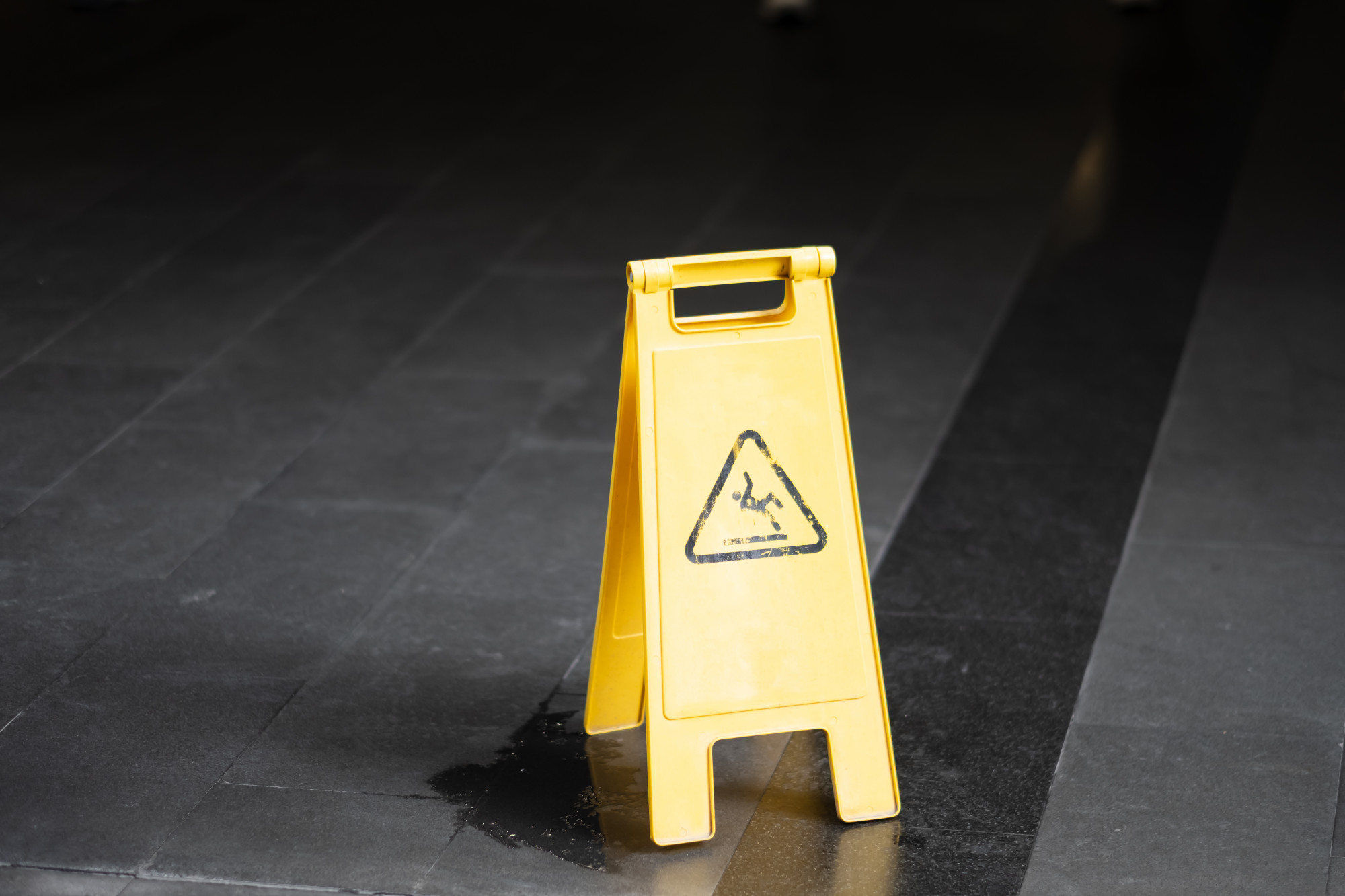 Roseville premises liability lawyers Gingery Hammer & Associates — wet floor sign where a person slipped and fell in a lobby